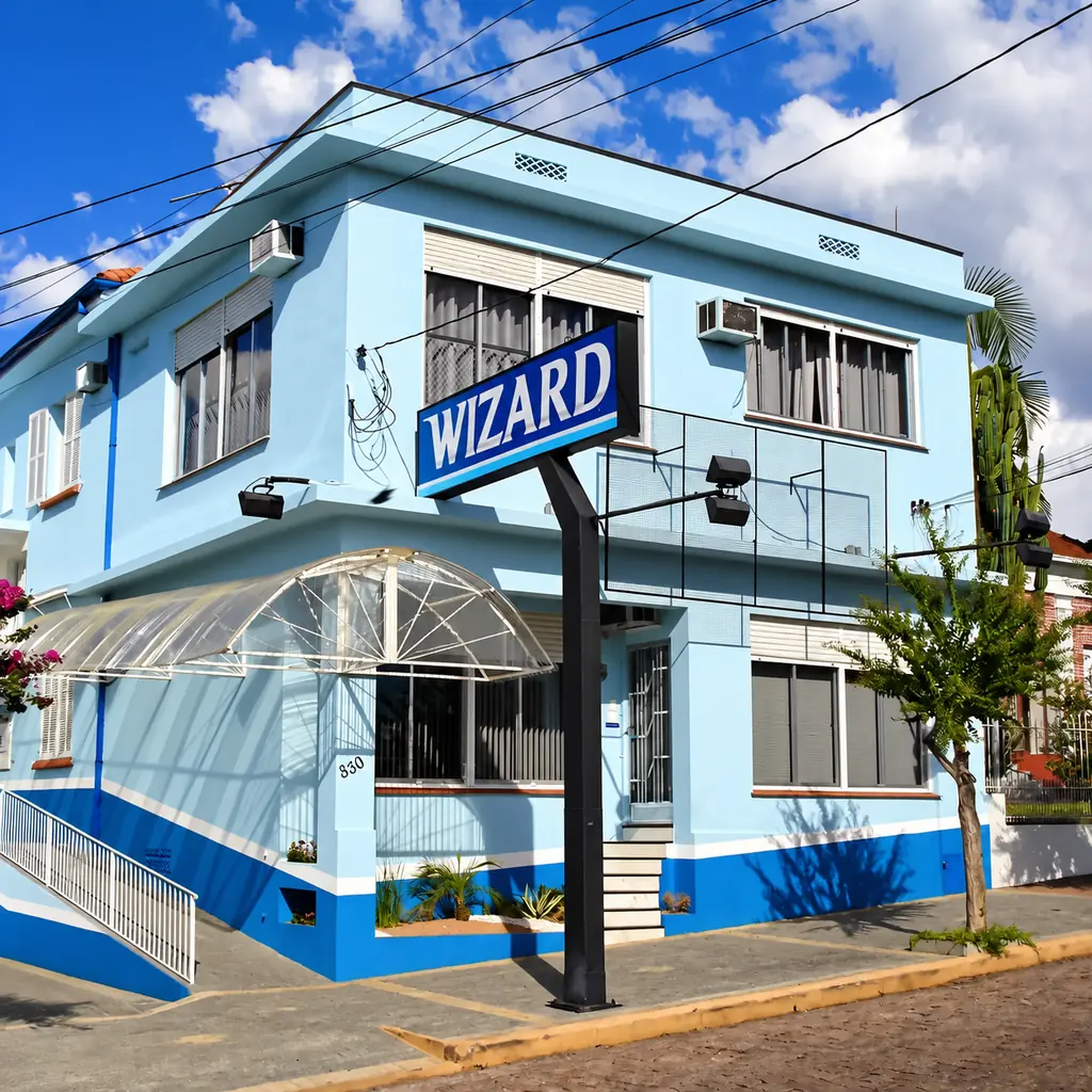 Foto histórica da Wizard Santa Cruz do Sul: casa azul e branca com placa da Wizard na esquina