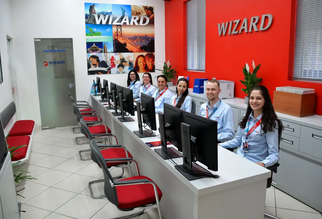 Equipe da secretaria da Wizard Santa Cruz do Sul sorrindo no balcão de atendimento